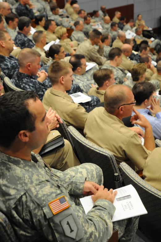 people in fatigues are sitting at the military convention