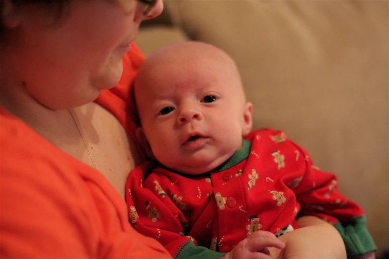 a baby in a christmas outfit looking up