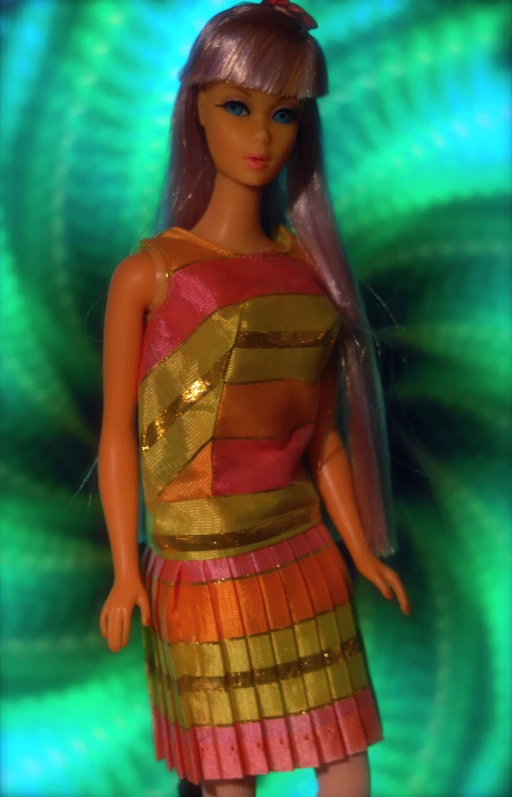 a doll is dressed in gold, red, and pink