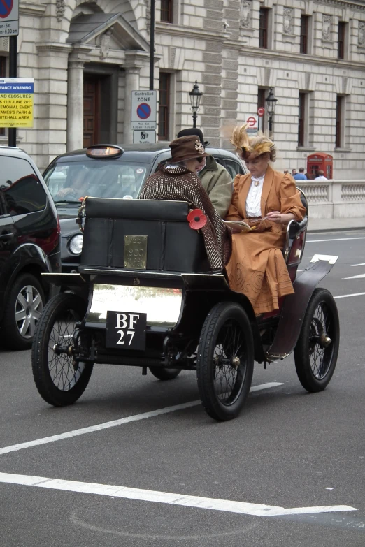 a man and woman sit in an old fashioned car