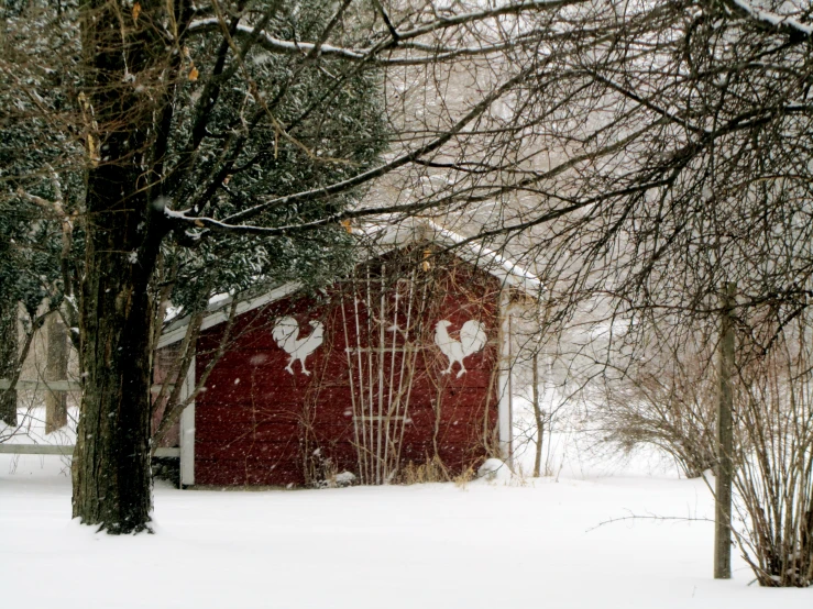 a barn with the doors partially covered and the snow surrounding