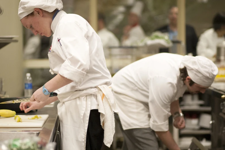 three chefs prepare food in a commercial kitchen