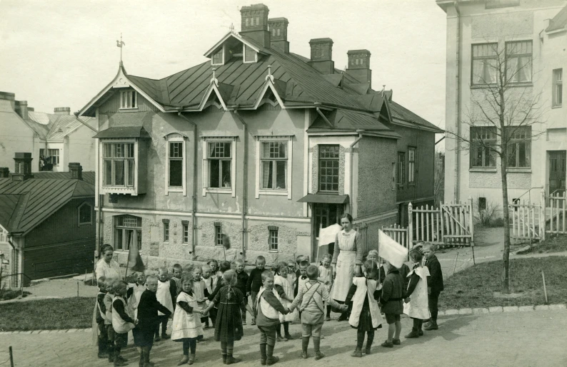 a group of people carrying their belongings past a house