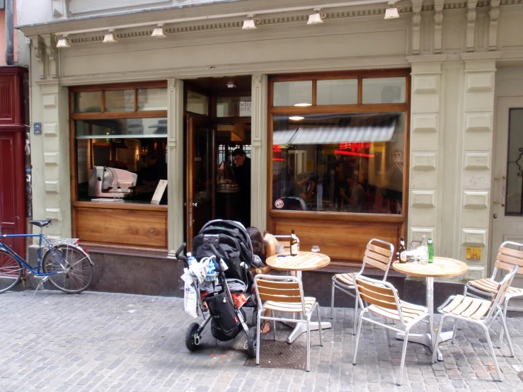 a table with chairs and a motor scooter outside a restaurant