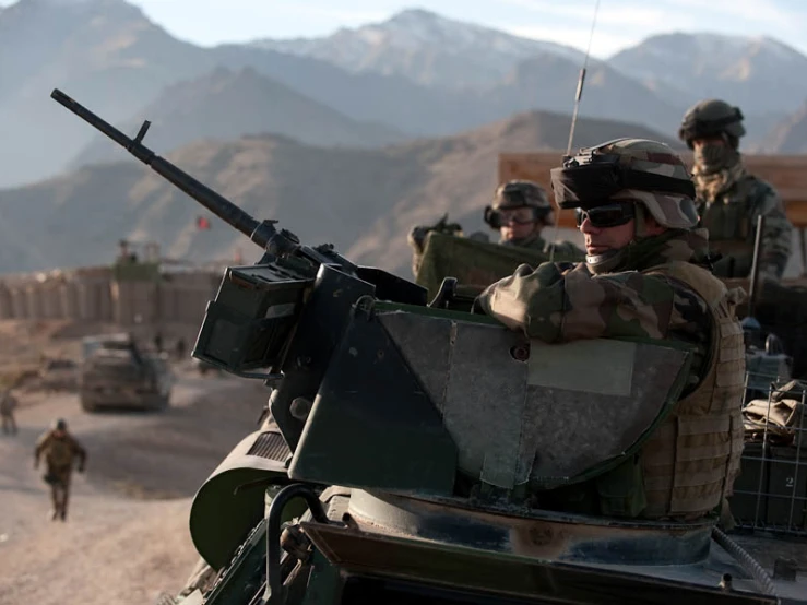 a soldier sitting in top of a tank