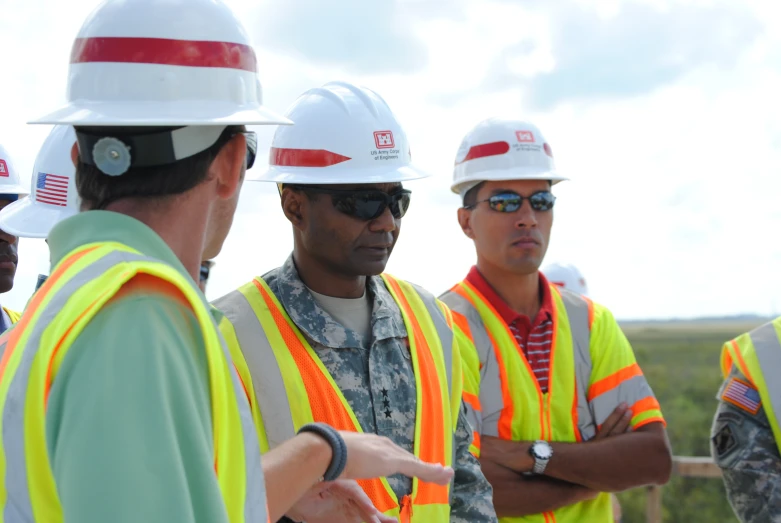 several men in vests and hard hats talking