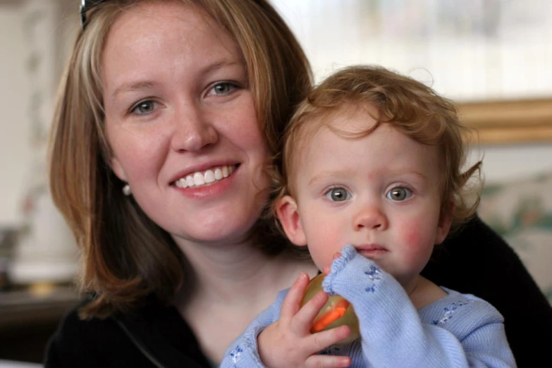 a woman holding a baby in a kitchen