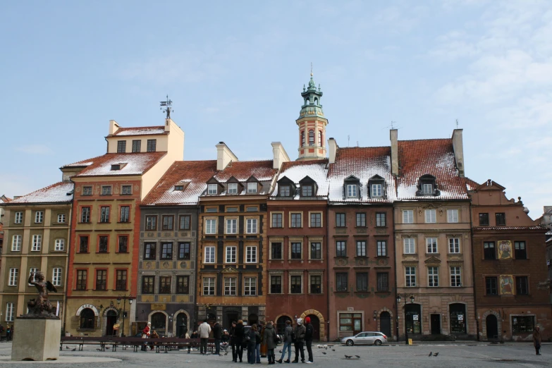 many people stand in front of the tall buildings