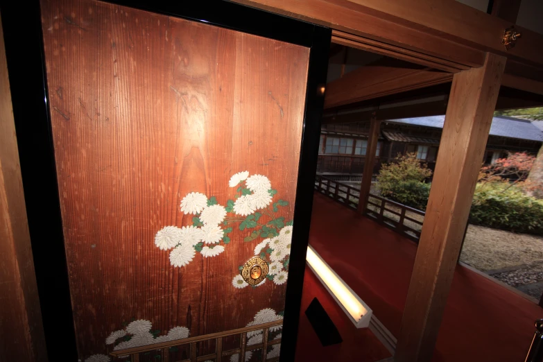 a wooden door with japanese flowers on it