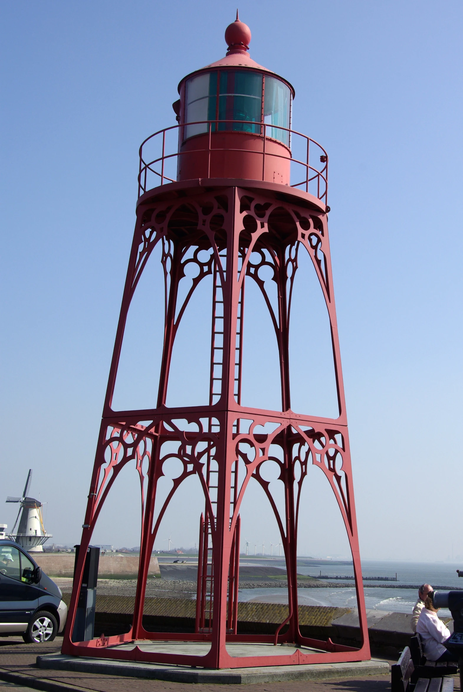 a tall red metal tower with a white and blue top