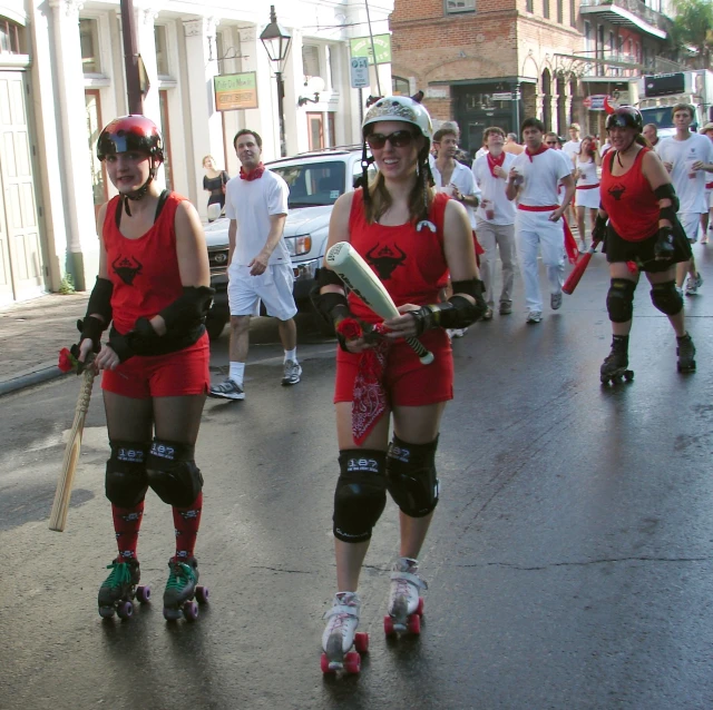 a bunch of skateboarders on the street wearing helmets and pads