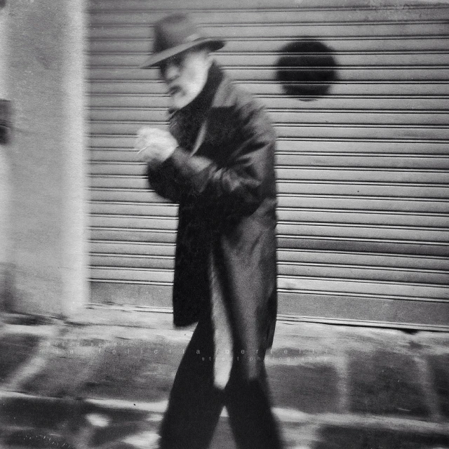 a man with a hat and coat in the rain