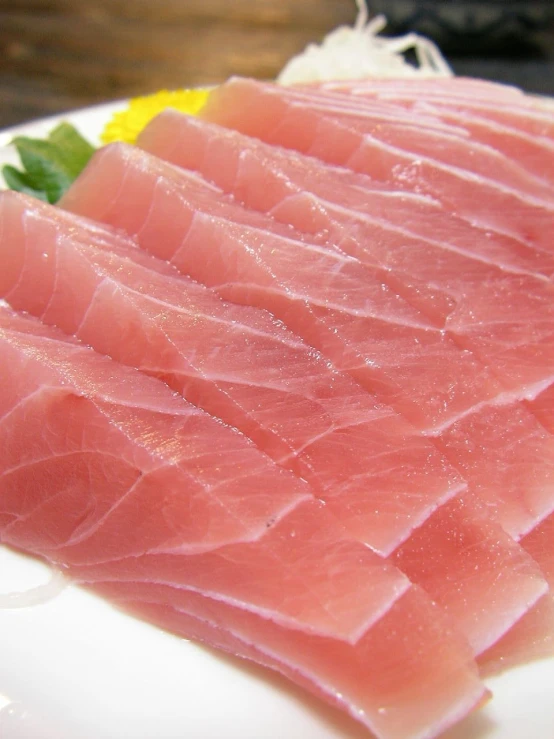 a plate filled with slices of raw fish