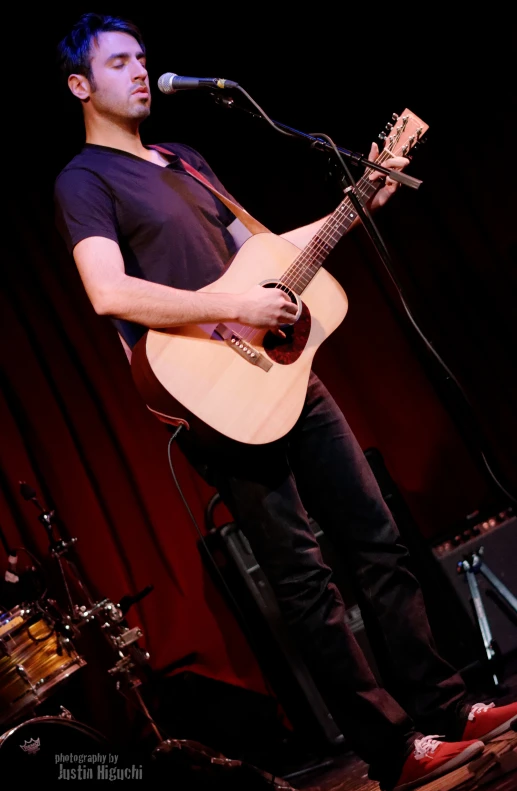 a man is singing and playing a guitar