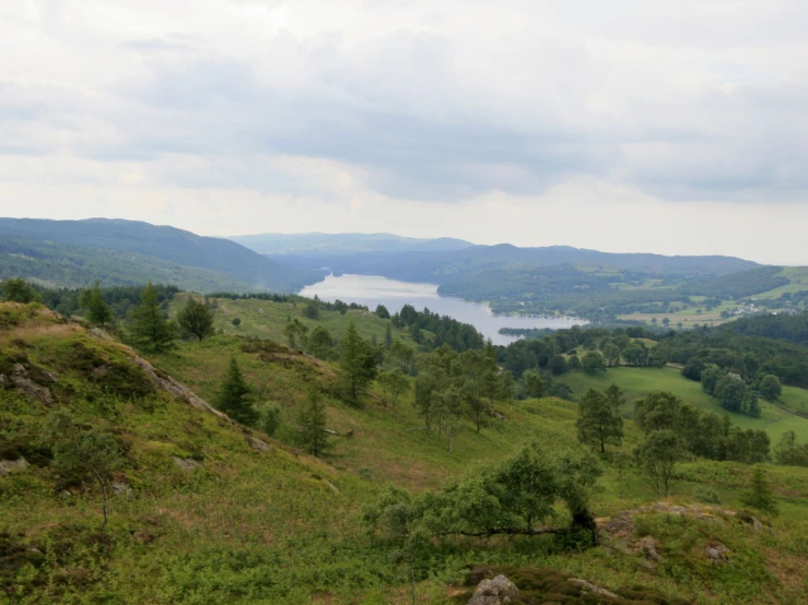 a valley with some green grass and water in the distance