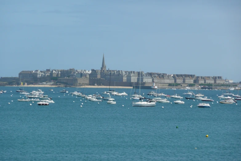 a bunch of boats floating in the water near a city