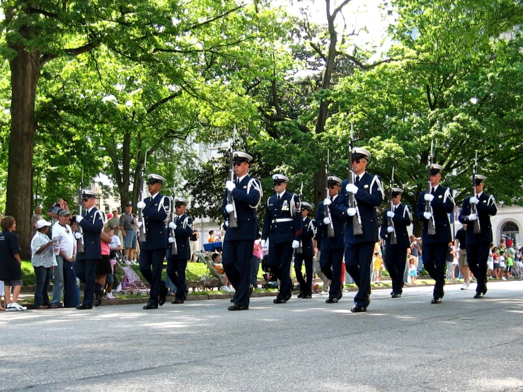 a parade going on in the street with several people standing around