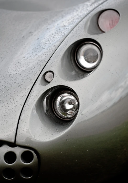 the front end of a shiny vehicle with its lights on