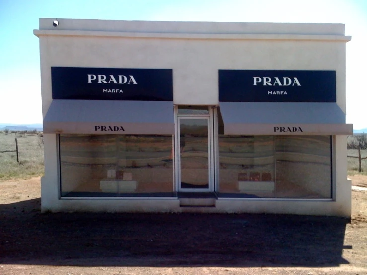 a small store front with two windows and the words prada in black on them