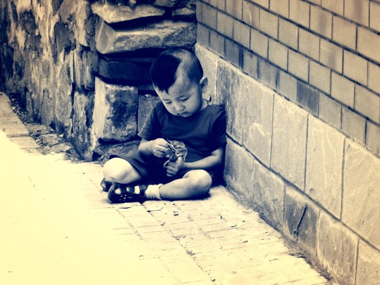 a small boy that is sitting on the floor with a skateboard