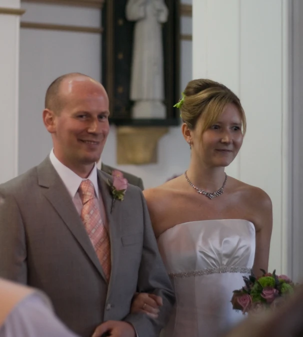 man and woman are standing together in a church