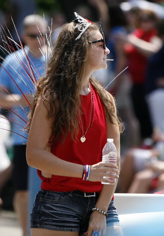 a young woman in black shorts and red shirt and some kind of silver hair on her head