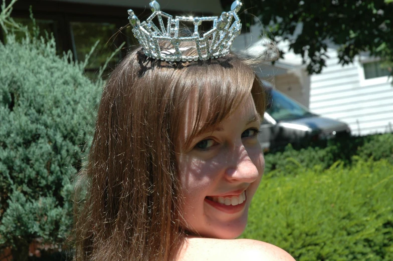 a woman with long brown hair wearing a tiara