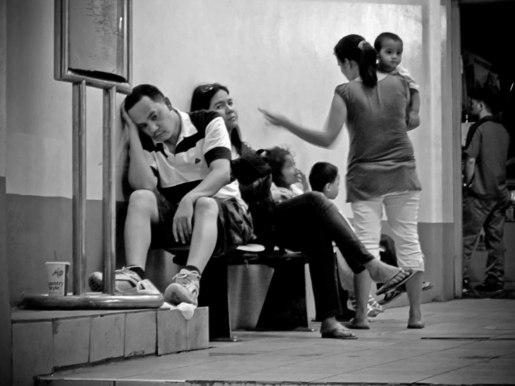 a group of people sitting next to each other in front of a building