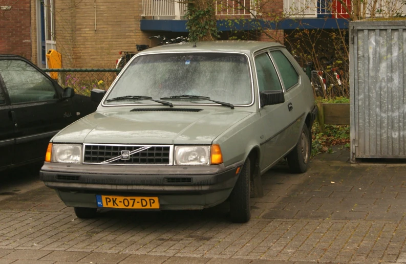 a gray car sitting next to a fence