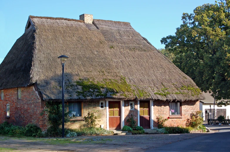 a cottage with thatched roof and a small window