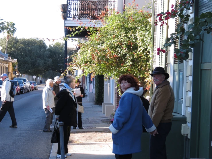 people on a sidewalk are walking down the street