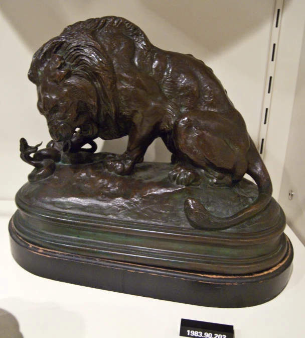 a bronze statue of a dog sniffing a flower