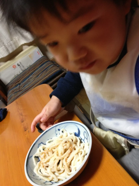 the little boy is looking at his food