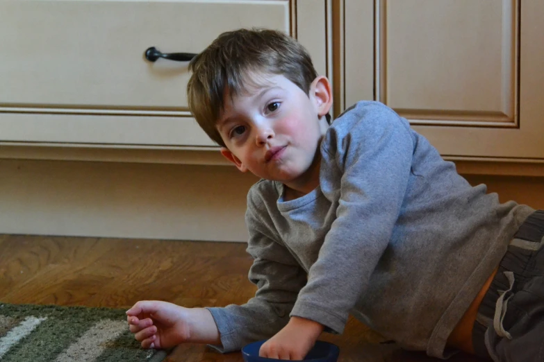 a  sitting on the floor holding a toy