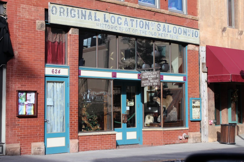 a brick store front has a brick awning and red awning