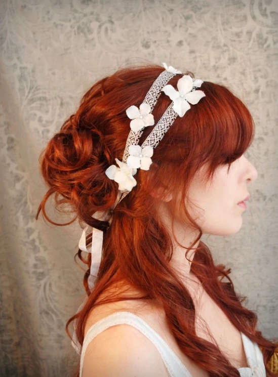 a red haired woman with wavy hair wearing a head piece made of pearls and crystal