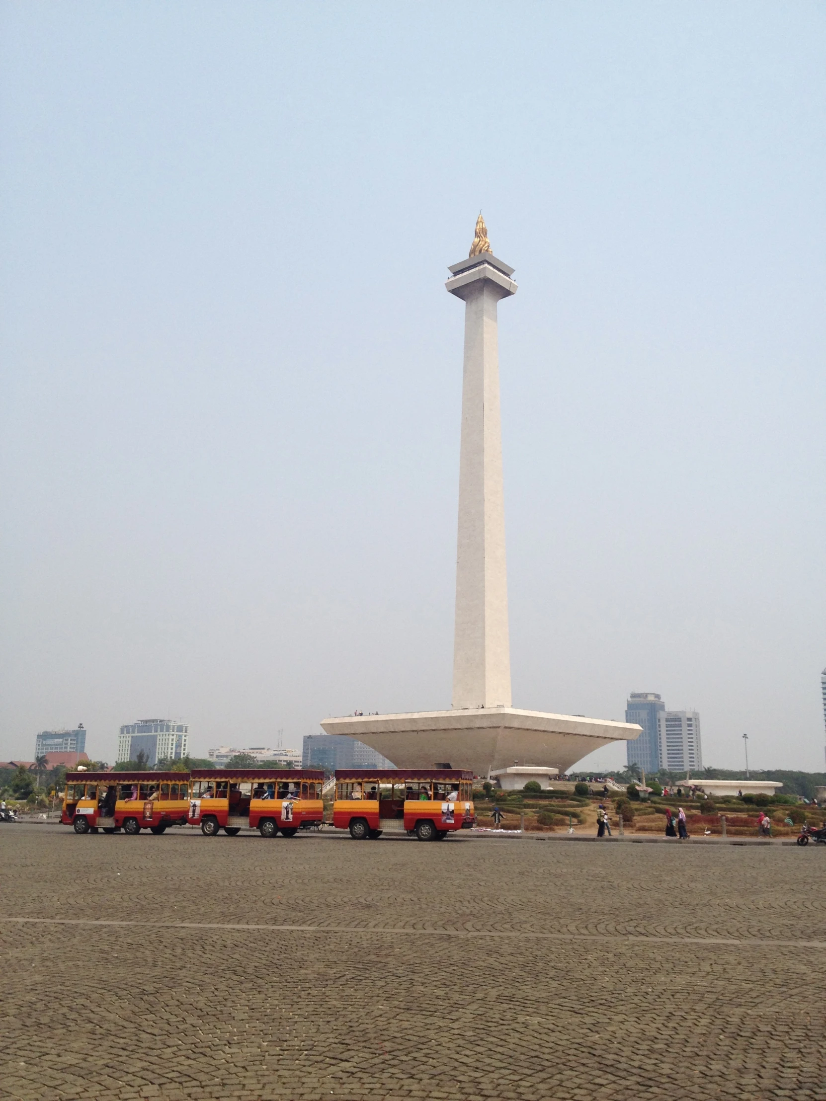 a large monument on the beach with a bunch of trucks parked near it