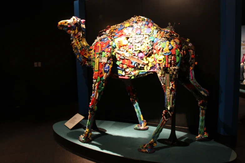 the sculpture of a very colorful camel made of small objects