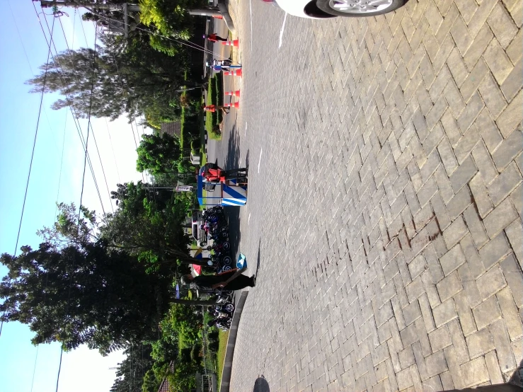 two men playing in the street while one stands on the sidewalk