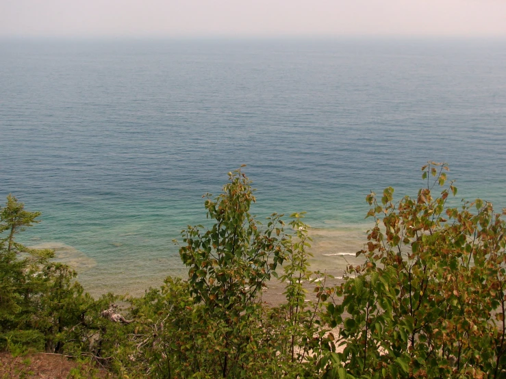 the view from the top of an hill that has a large body of water