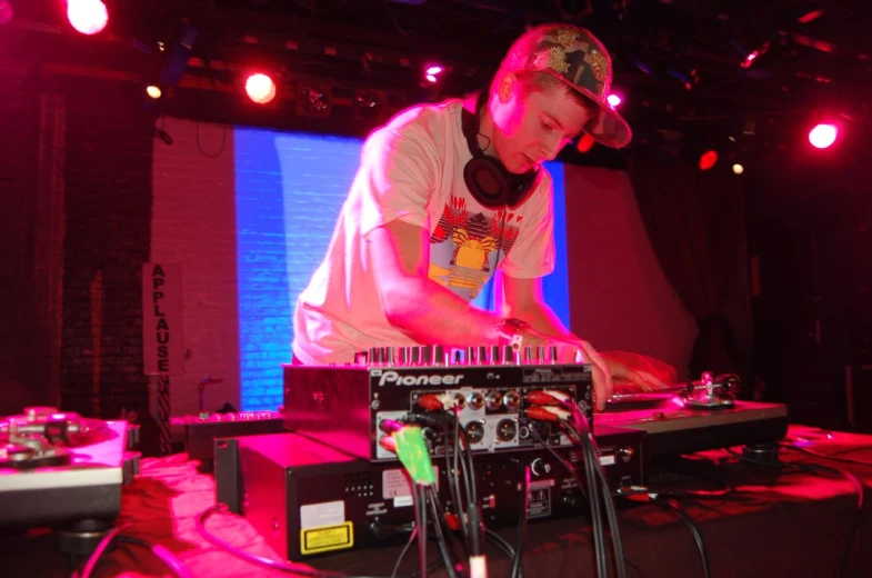 a man wearing headphones standing at a dj's table