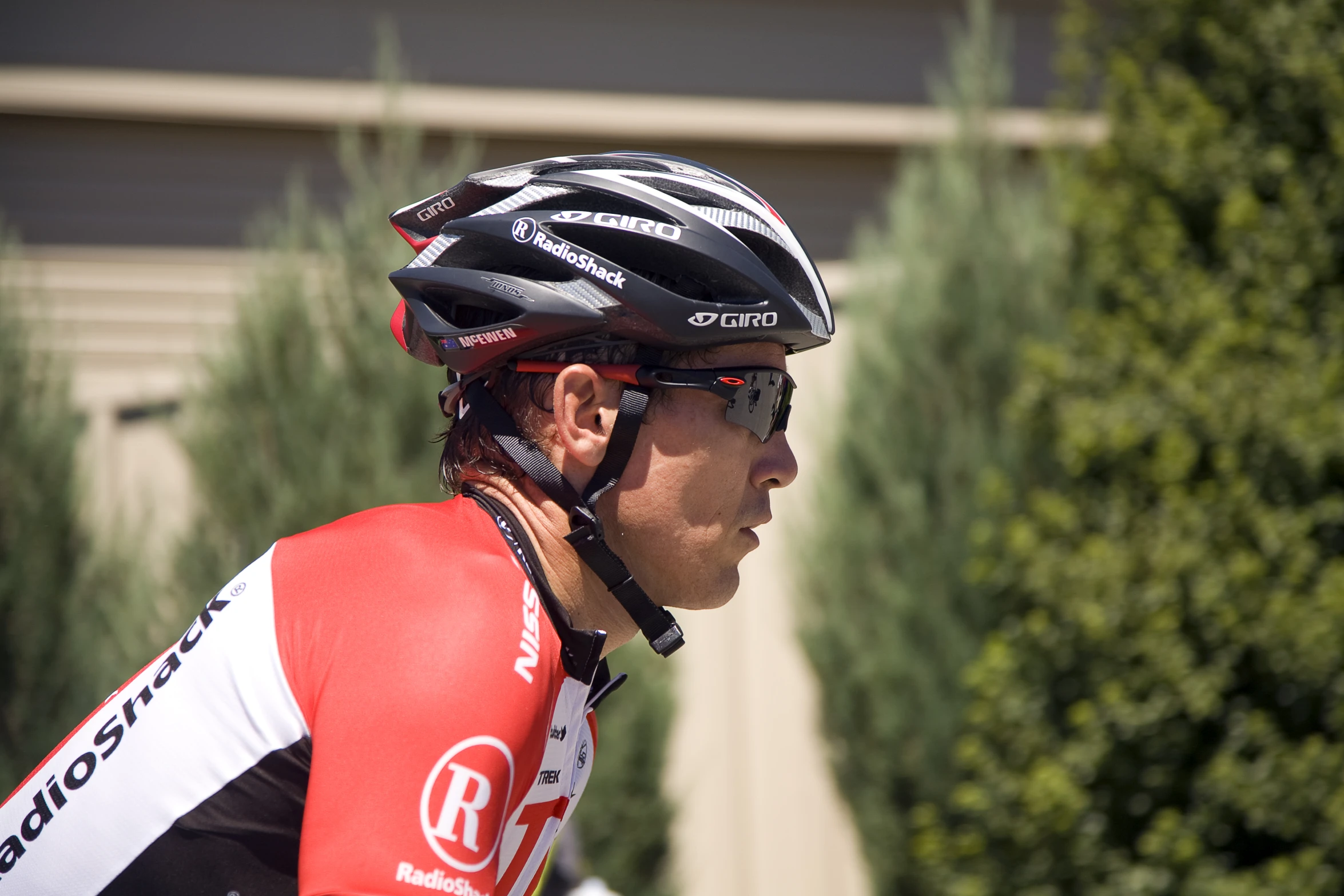 a man in a bib, red shirt and helmet looks to his right