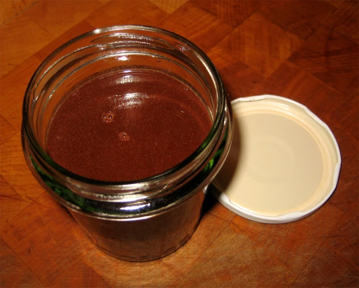 there is an empty glass jar with red liquid in it