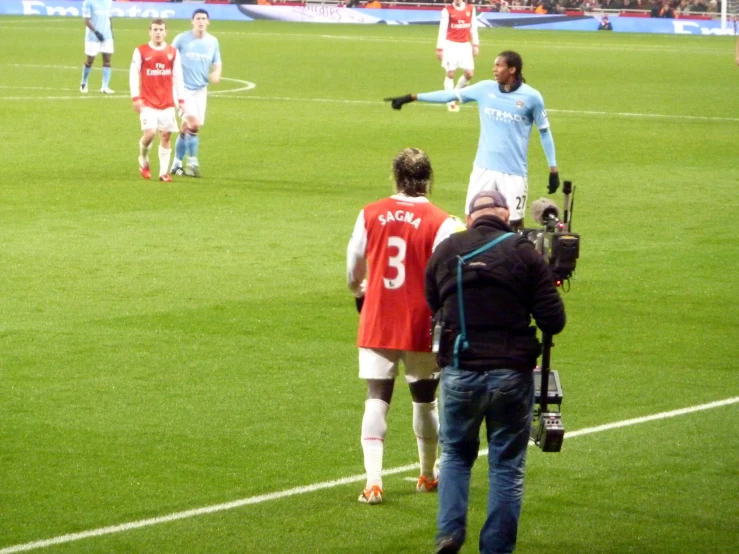 a man standing on a soccer field with a camera