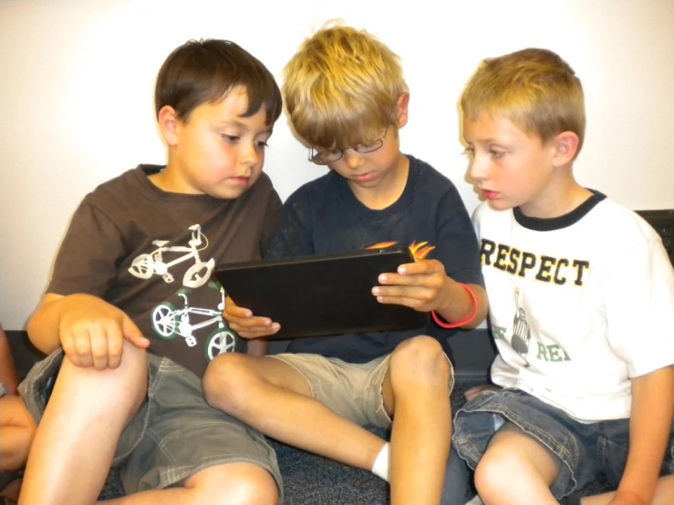 three children sitting on top of a couch