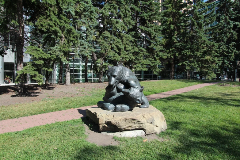 a stone bench in a park with trees and buildings in the background