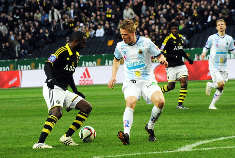 soccer player going after ball while playing in front of audience