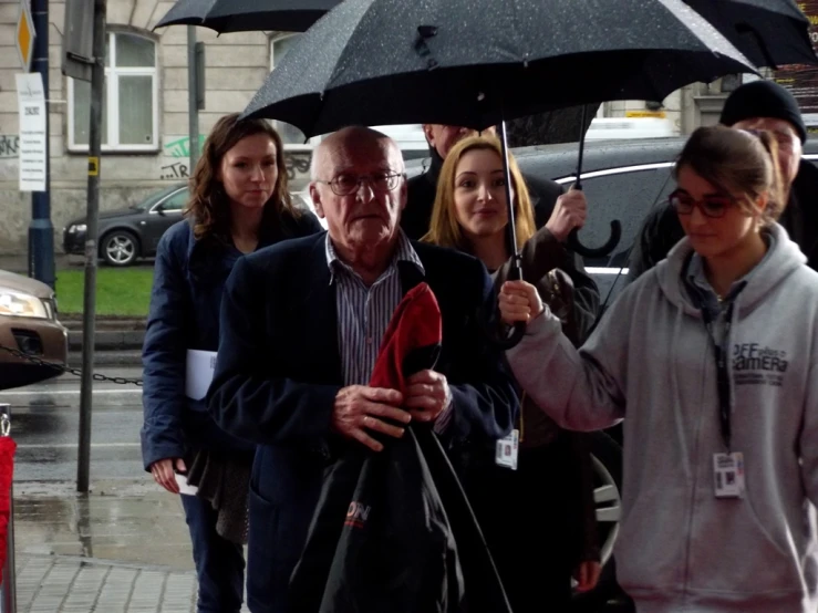 an older man with an umbrella is walking down the street