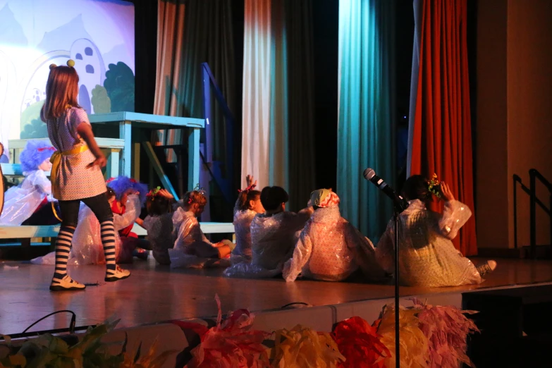 children are performing on stage with their costumes