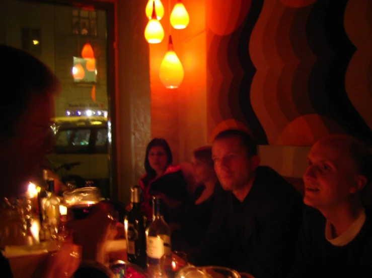 a group of people sitting around a table with food